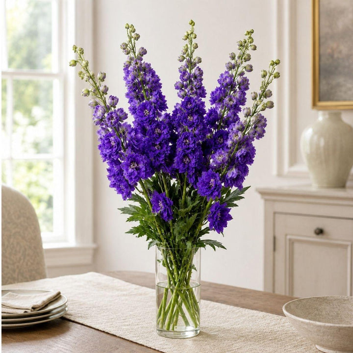 Delphiniums Purple Heart fresh-cut flowers arranged in a clear vase at home, from Sharbatly.