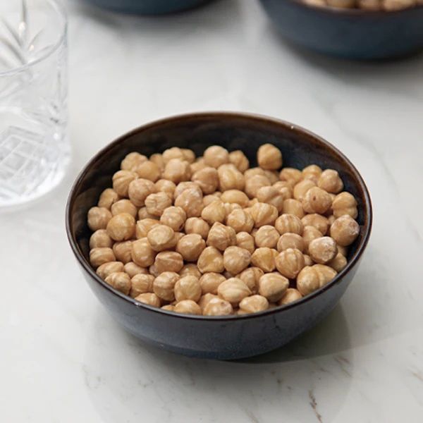 Roasted hazelnuts in a 0.25 kg pack from Fresh Nuts, showing golden-brown nuts in a clear view.