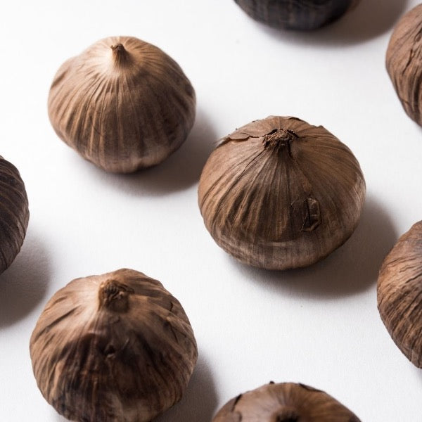 Black garlic in a 0.05kg pot from Sharbatly, fresh vegetable with dark, caramelized cloves visible in the container.