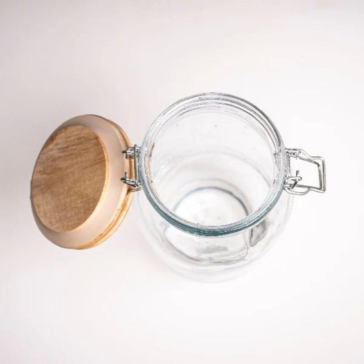 Top view of an empty glass jar with its wooden lid open, from Sharbatly.