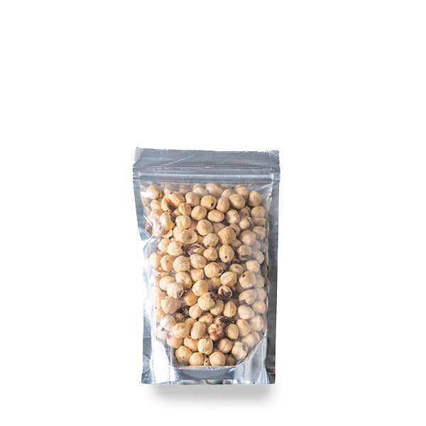 All-natural hazelnuts in a 0.25 kg pack from Fresh Nuts, showing whole, roasted hazelnuts on a wooden surface.
