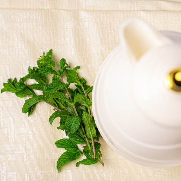 Fresh organic mint herb from Naqwat Al Nana, 0.2 kg pack, shown in a natural green bundle for culinary use.