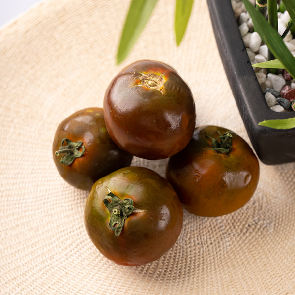 Fresh Kumato tomatoes in a 1 kg pack from Groots, vibrant red and green vegetables on display.