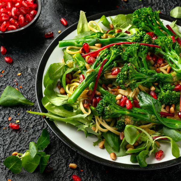 Fresh Holland Tenderstem broccoli in a 0.15 kg pack, showing vibrant green vegetable stalks and florets on a white background.
