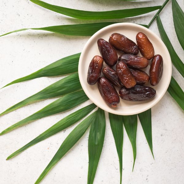 Pack of Sharbatly Ambar dates, 0.50 kg, showing glossy, ripe dates with smooth, dark brown skin in a clear plastic pack