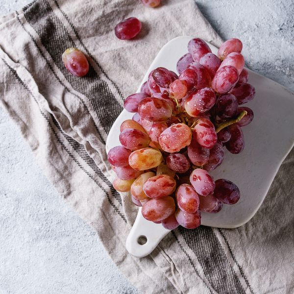 Red Globe grapes in a 4 kg carton, fresh and ripe Sharbatly fruit, showing clusters of vibrant red grapes.