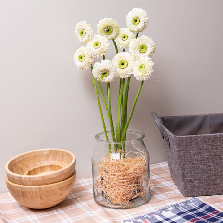 Bright pink Gerbera flowers from the Mona collection by Flowranow, displayed in a bouquet with green leaves.