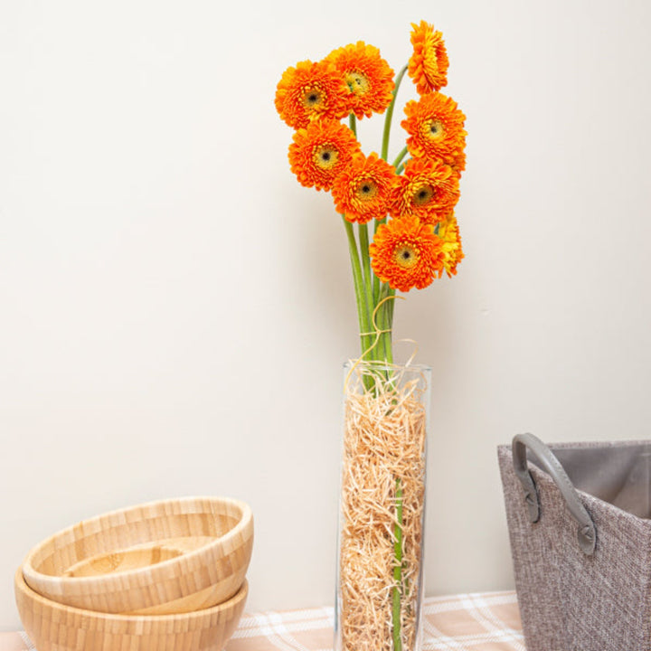 Bright orange Gerbera daisies from Flowranow, arranged in a bouquet with 10 stems, showcasing vibrant blooms and green foliage.