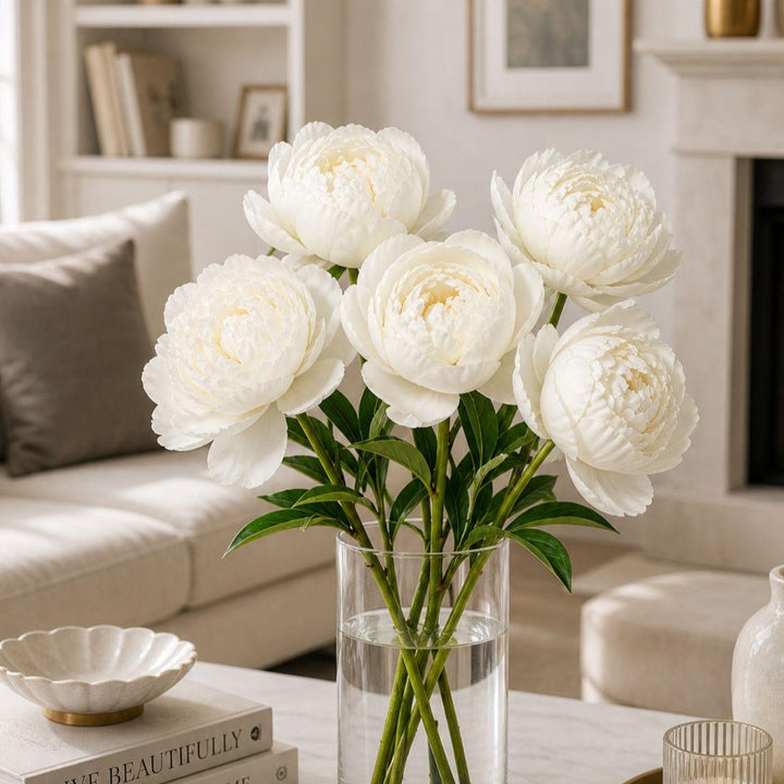 White peony flower stems from Fresh Flower Holland, showing five fresh, full blooms with lush green leaves.