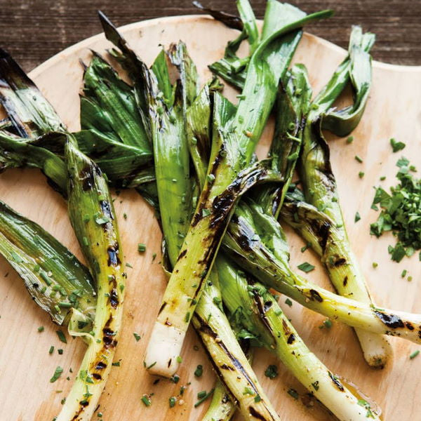 Fresh baby leeks from Holland in a 0.2 kg vegetable pack, showcasing their long green stalks and white bases.