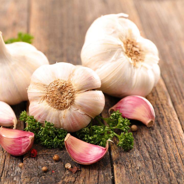 White garlic in a 0.2 kg Sharbatly vegetable bag, fresh and whole, with visible cloves and papery skin.
