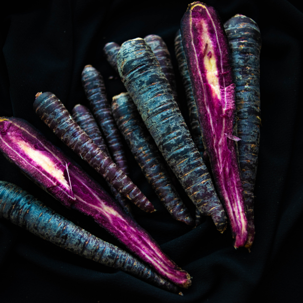 Purple carrots from Holland, 1 kg pack, fresh violet-colored vegetable with leafy greens attached.