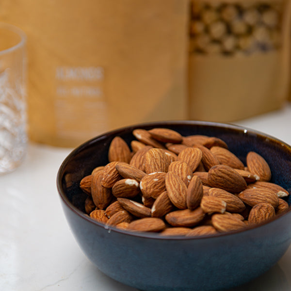All-natural almonds in a 0.25 kg pack from Fresh Nuts, showing a close-up of whole, raw almonds with textured brown shells.