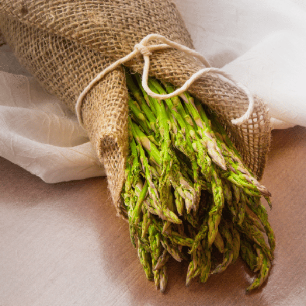 Fresh baby asparagus spears from Thailand in a 0.1 kg pack, showcasing vibrant green vegetable tips on a white background.