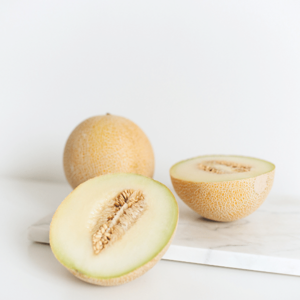 Fresh sweet local melon fruit from Local Market, single piece with vibrant green rind and orange flesh, ready to eat.