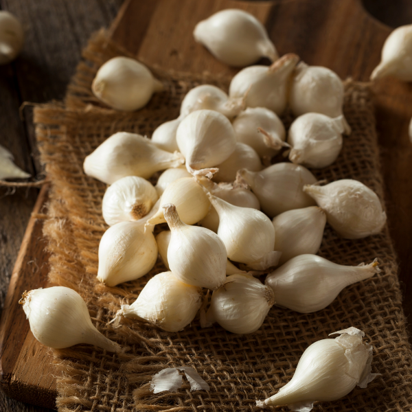 White pearl onions from Holland in a 0.5 kg pack, fresh vegetable with smooth, round white bulbs shown in the image.