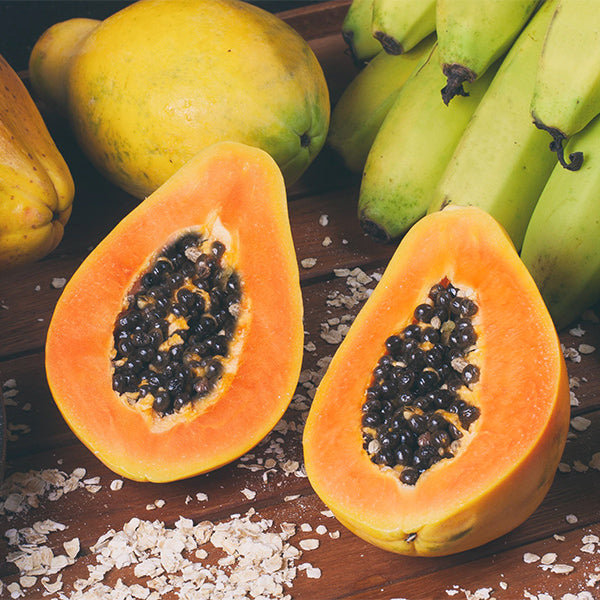 Fresh Tainung Formosa papaya from Thailand, whole ripe fruit with vibrant orange flesh and smooth green skin.
