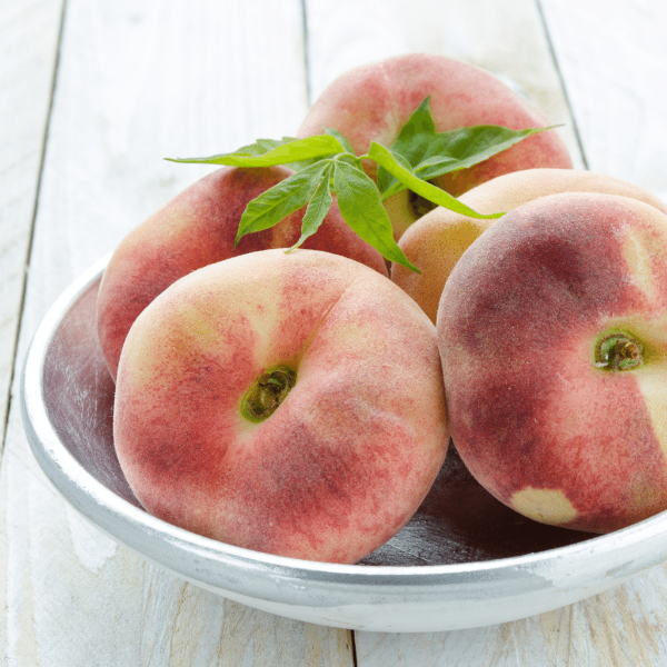 Fresh white-flesh peaches in a 1 kg pack from Sharbatly, showcasing ripe, juicy fruit on a white background.