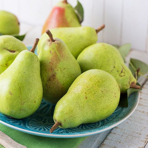 Fresh Coscia pears from Sharbatly in a 1 kg pack, showcasing ripe, green fruit with smooth skin on a wooden surface.