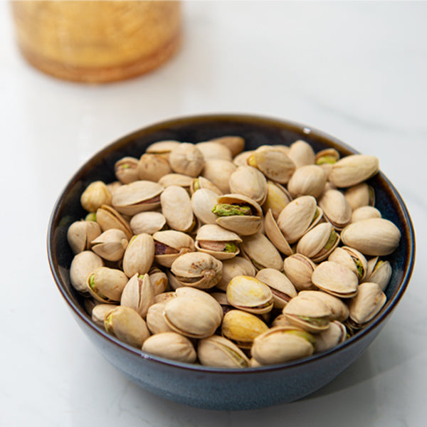 All-natural pistachios from Fresh Nuts in a 0.25 kg pack, showing green and tan shelled nuts ready to eat.
