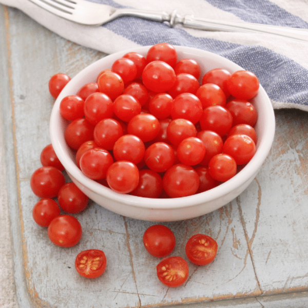 Holland Tomberry red vegetable in a 0.125 kg pack, showcasing bright red, small round tomatoes on the vine.