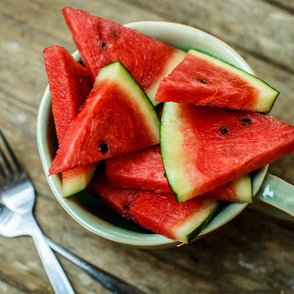 Fresh, juicy watermelon slice from Sharbatly, showcasing vibrant red flesh and green rind on a clear background.