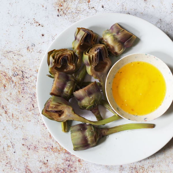 Fresh Artichoke Baby Violet vegetables from Holland, 1 kg pack, showcasing vibrant purple artichokes with leafy green stems.