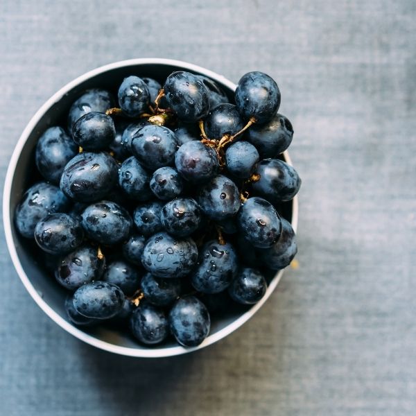 Black seedless grapes in a 0.5 kg pack, fresh and ripe, from Sharbatly, displayed in a clear plastic container.