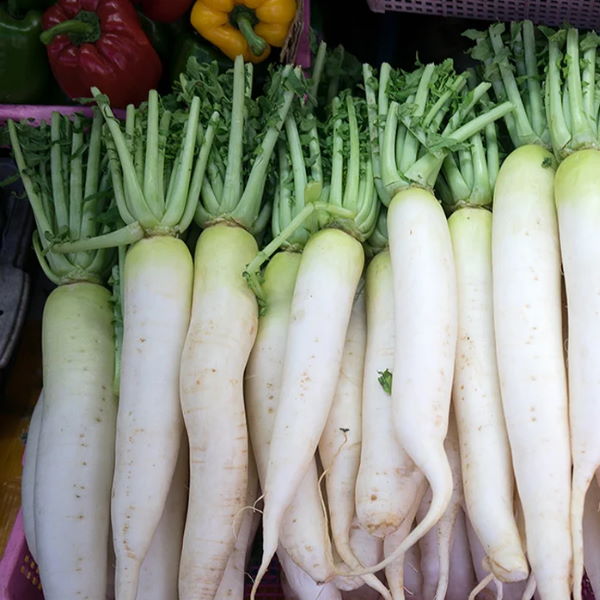 Fresh daikon radishes from Local Market, 1 kg pack, showcasing white, elongated vegetables with leafy green tops.