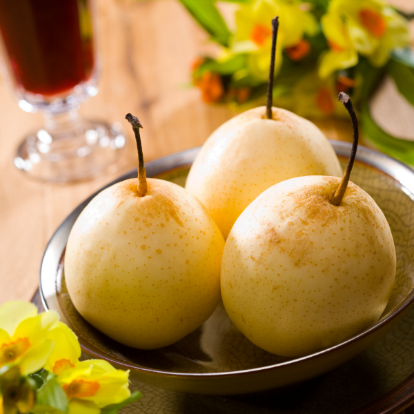 Fresh Nashi pears from Sharbatly, 3 kg carton, showing ripe, round fruit with smooth skin in a natural setting.