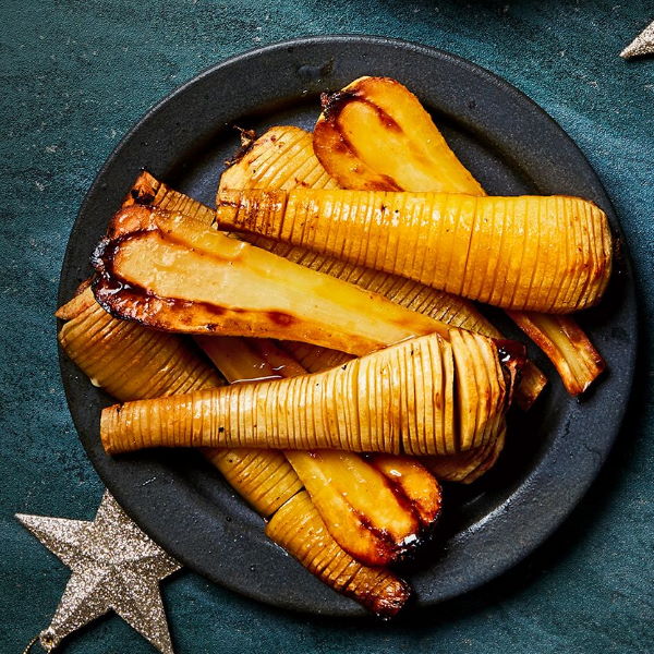 Fresh Holland parsnips in a 1 kg vegetable pack, showcasing their white, elongated roots and leafy green tops.