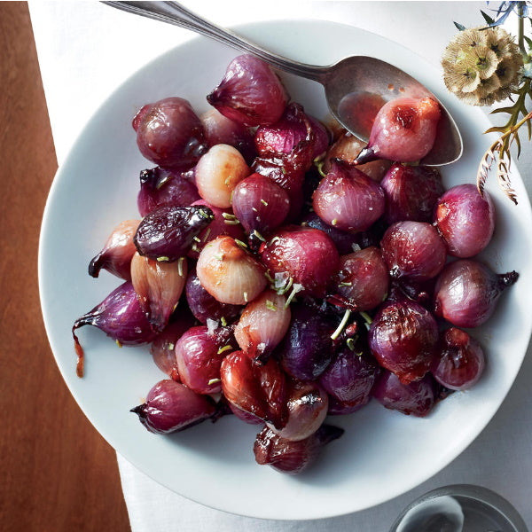 Fresh Red Pearl onions in a 0.5 kg pack from Holland, showing vibrant red bulbs and green stems.