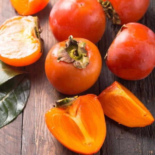 Fresh persimmons in a 1 kg pack by Sharbatly, showcasing bright orange kaki fruit on a white background.