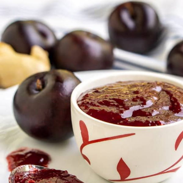 Red Sharbatly plums in a 1 kg pack, fresh and ripe, showcasing vibrant red skin and juicy interior.