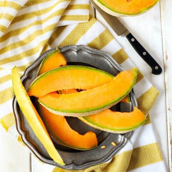 Single ripe cantaloupe melon from Holland, showcasing its orange flesh and textured rind, fresh and ready to enjoy.