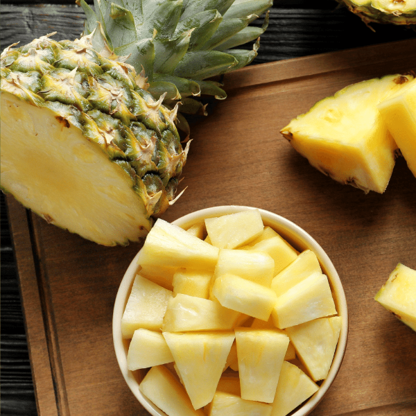 Golden pineapple from Sharbatly, single fresh fruit piece with spiky green leaves and textured yellow skin.